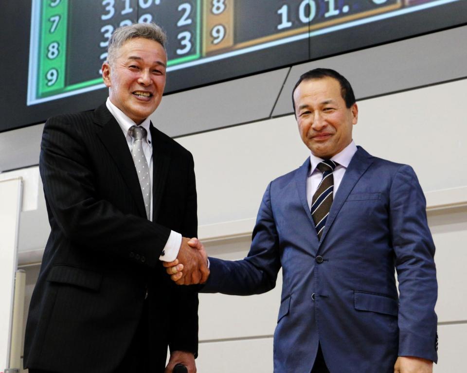 　握手をかわす本紙評論家・伊藤豊明（右）、本田晴美両氏