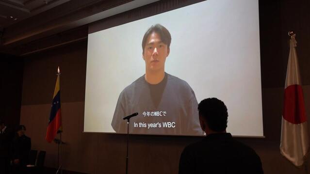 ビデオメッセージを寄せた山本由伸を見つめるマチャド（手前）