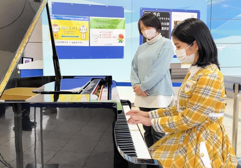 期間限定で設置された「復興空港ピアノ」を演奏するＫＯＢｅｒｒｉｅＳ♪の花城沙弥（右）と、所有者の櫻井由美さん＝宮城県名取市の仙台空港
