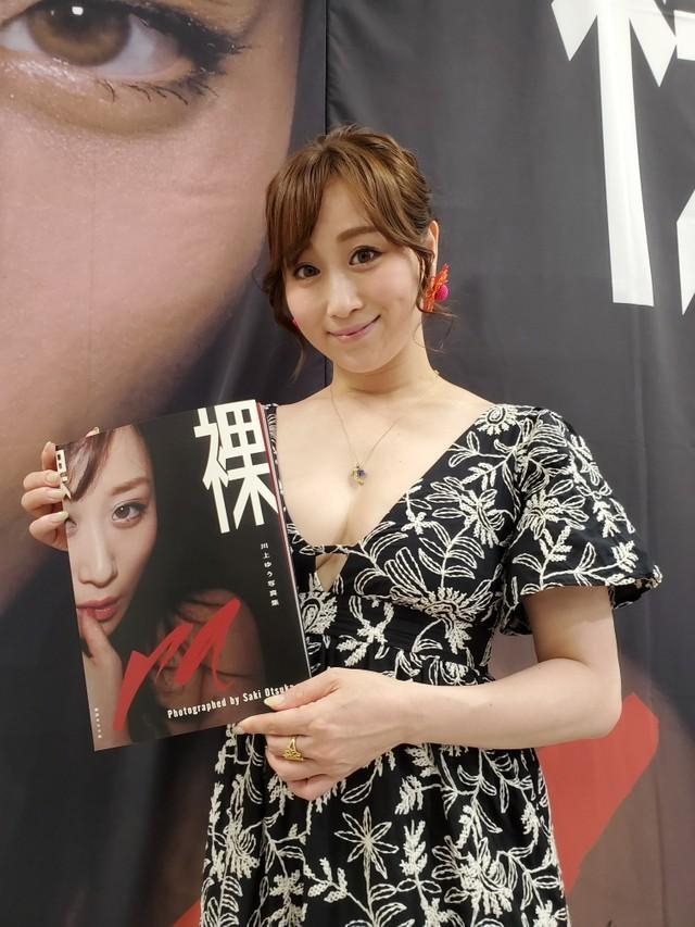 自身の写真集を手にするAV女優・川上ゆう。「写真集はこれが最後」と明かし、業界入りした原点も語った＝都内