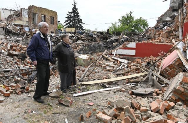 ハルキウ空港近く、破壊された民家の残がいをぼう然と見つめるウクライナの人たち（撮影・釣崎清隆）