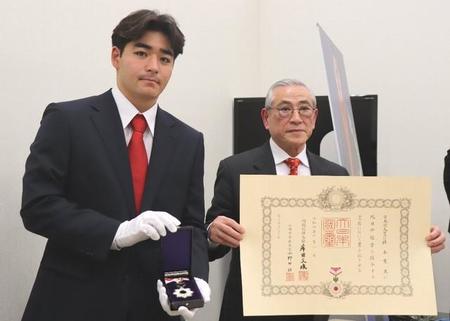 アントニオ猪木さんに授与された勲章「旭日中綬章」を披露する孫の猪木寛太さん（左）と弟の啓介氏＝国会内