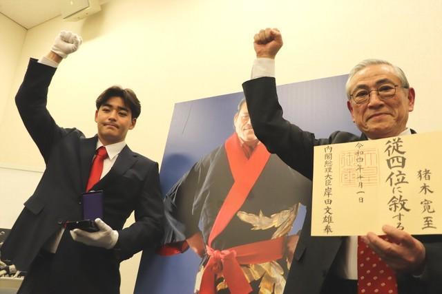 アントニオ猪木さんに授与された位階「従四位」とともに「ダァ～！」のポーズを見せる孫の猪木寛太さん（左）と弟の啓介氏＝国会内