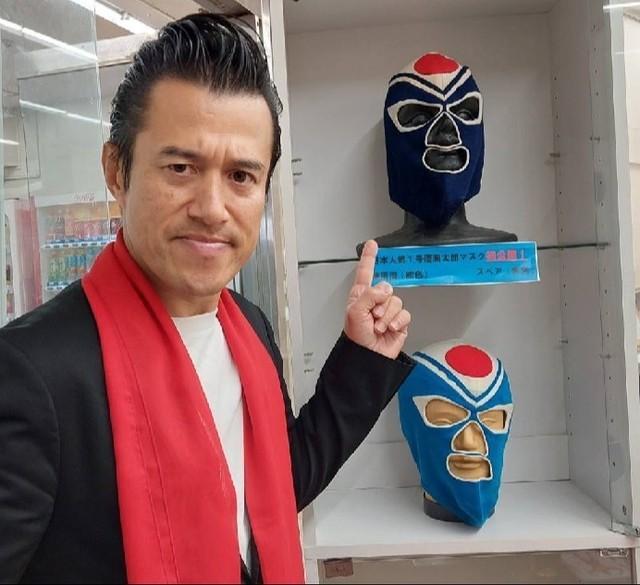 「ストロング小林展」で展示された秘蔵の覆面太郎マスク（黒と青２種類）を前に思いを語るアントニオ小猪木＝東京都青梅市