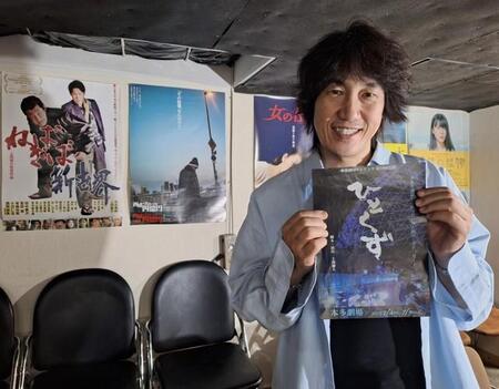 稽古場で舞台「ひとくず」のチラシを手にする上西雄大。映画監督、舞台演出家、脚本家、俳優とマルチに活躍する＝都内