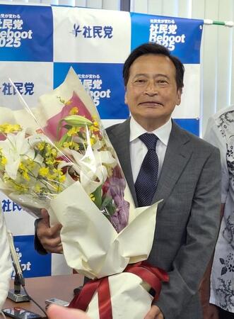 参院選の社民党比例代表候補として出馬して当選し、花束を手に会見に臨むラサール石井＝都内