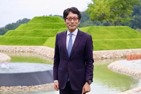 自身が手がけた前方後円墳墓の前に立つ竹田恒泰氏