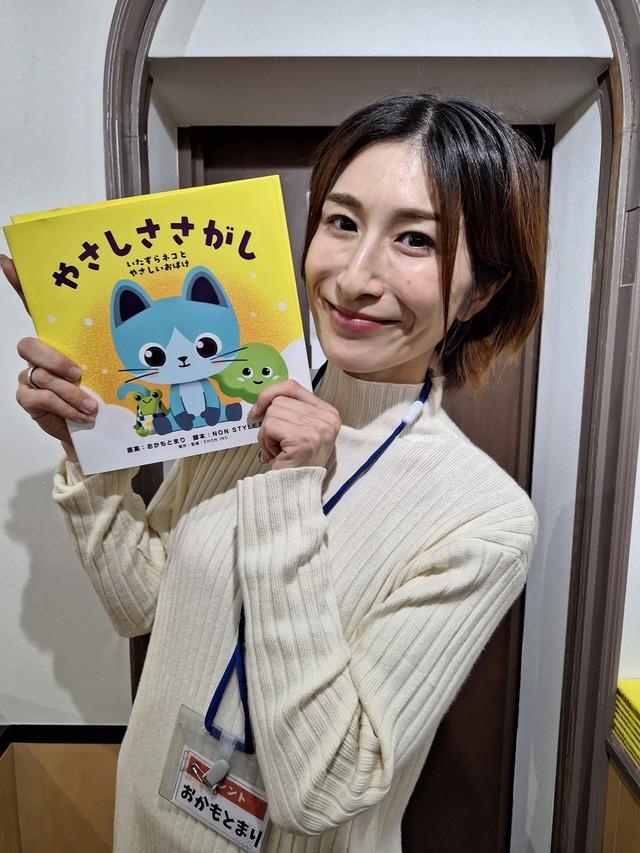 自身の原案で今年出版された絵本「やさしささがし」を手にするクリエイター・おかもとまり＝都内