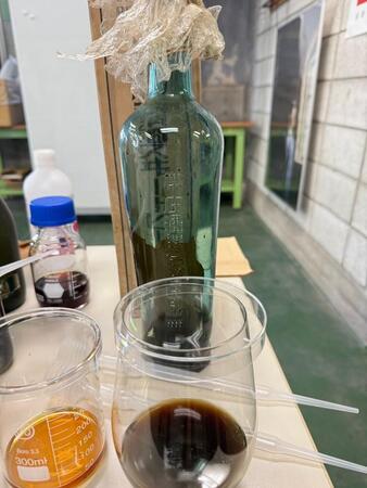 こちらが100年前の日本酒。熟成してかなり濃い色味に（白木滋里さん提供）