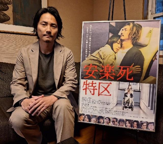 主演映画「安楽死特区」のポスターを前に「安楽死」というテーマについて語る俳優の毎熊克哉＝都内