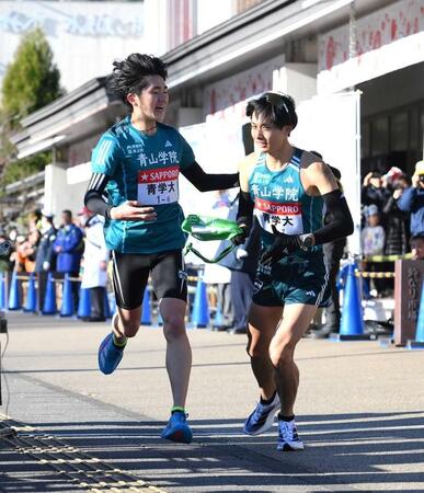 3日、たすきをつなぐ青学大・石川浩輝（左）。右は佐藤愛斗