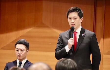 大阪維新の会全体会議の冒頭であいさつする吉村洋文氏（左は横山英幸氏）＝大阪市内