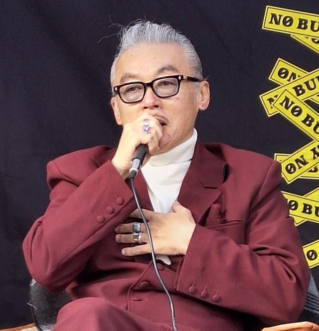 胸に手を当て、自身の体験を踏まえて「いじめ問題」について持論を語る田代まさし氏＝神奈川・茅ヶ崎市役所前