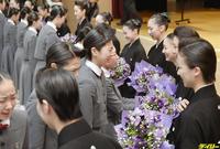 　宝塚音楽学校の卒業式で、後輩の予科生（左側）からブーケを贈られる卒業生たち＝２日午前、兵庫県宝塚市