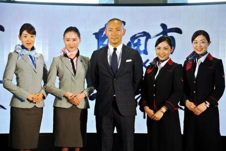 　キャビンアテンダントと写真に収まる市川海老蔵＝成田空港