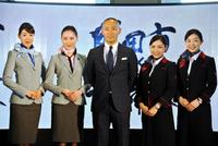 　キャビンアテンダントと写真に収まる市川海老蔵＝成田空港