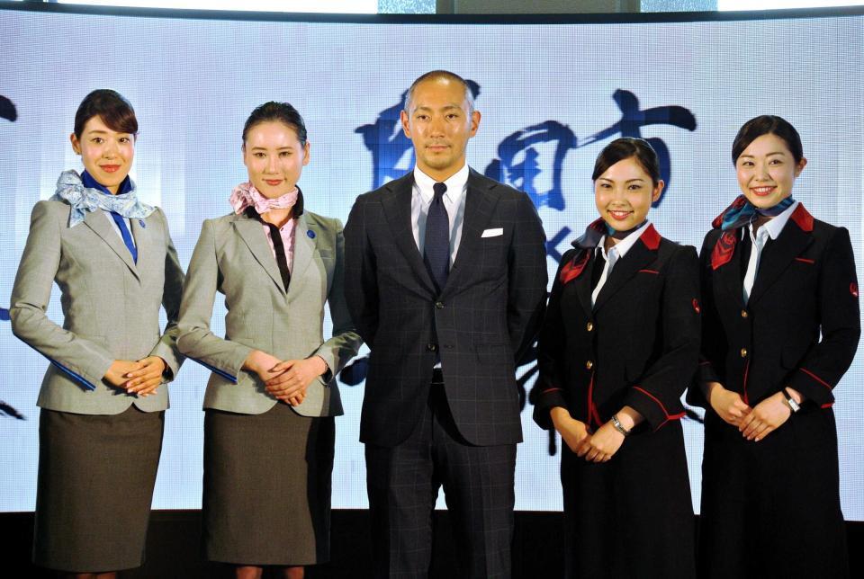 　キャビンアテンダントと写真に収まる市川海老蔵＝成田空港