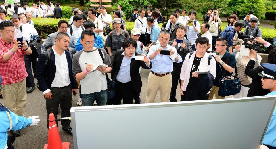 　清原和博被告の裁判傍聴券当選番号を確認する人たち＝日比谷公園