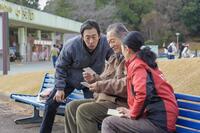 万博公園の入り口近くで、息子・聖人（北村有起哉・左）たちと楽しそうな永吉（松平健）