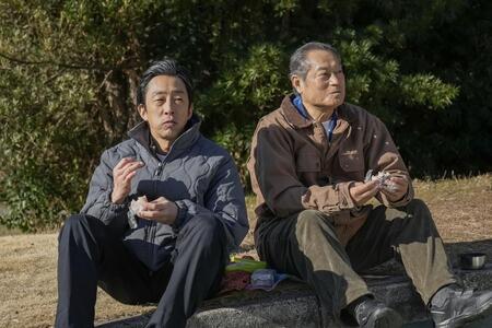 太陽の塔の前で、おむすびを食べる聖人（北村有起哉・左）と父・永吉（松平健）