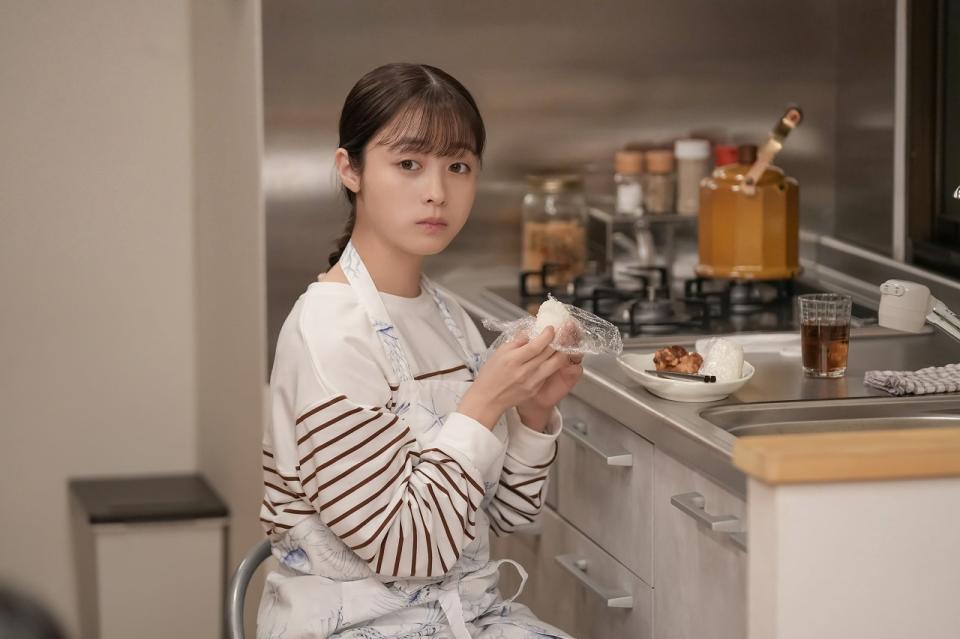 キッチンで、家族から離れておむすびを食べる結（橋本環奈）