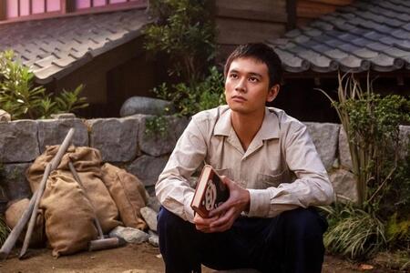 本を手に物思いにふける嵩（北村匠海）