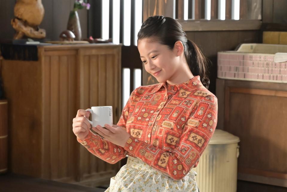 嵩の詩とイラストが入ったマグカップを愛おしそうにみつめるのぶ（今田美桜）