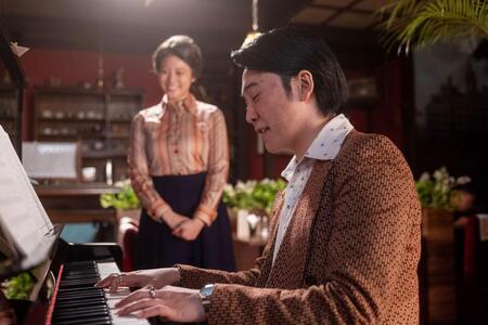 ピアノを弾きながら嵩の書いた歌詞を口ずさむたくや。左から、のぶ（今田美桜）、たくや（大森元貴）