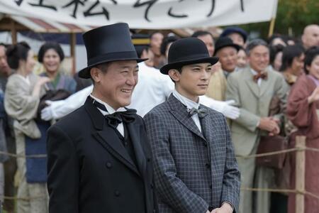 ヘブンを出迎える知事・江藤（佐野史郎・左）、英語教師・錦織（吉沢亮）は誇らしげな表情