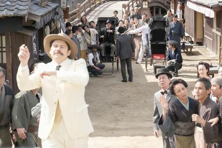 ヘブン（トミー・バストウ）よ、どこへ行く…！知事の江藤（佐野史郎・中央）もびっくり！観衆も首を傾げて