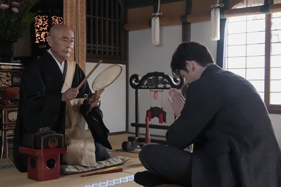 大雄寺の住職（伊武雅刀）からお祓いを受けるヘブン（トミー・バストウ）