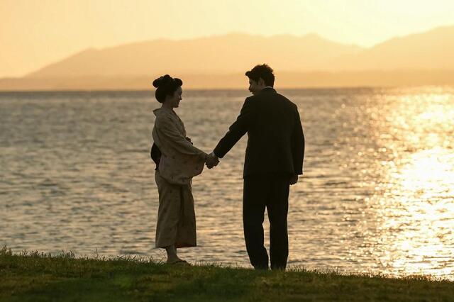 手を取り合うふたり。左から、トキ（高石あかり）、ヘブン（トミー・バストウ）