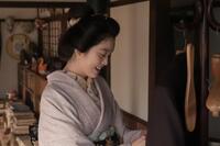 ヘブンの上着を手に優しく笑みを浮かべるトキ（高石あかり）