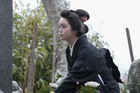 ヘブンの墓にそっと花を供えるトキ（高石あかり）