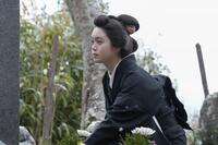 ヘブンの墓にそっと花を供えるトキ（高石あかり）