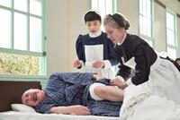 患者・園部（野添義弘）の看護をするバーンズ先生（エマ・ハワード）と、りん（見上愛）