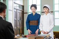 院長の前でたたずむツヤ（東野絢香・左）、りん（見上愛）