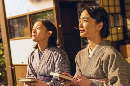 りん（見上愛・右）執筆の看護の実用書を手に、思いをはせるりんと直美（上坂樹里）