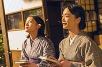 りん（見上愛・右）執筆の看護の実用書を手に、思いをはせるりんと直美（上坂樹里）