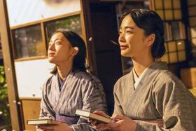 りん（見上愛・右）執筆の看護の実用書を手に、思いをはせるりんと直美（上坂樹里）