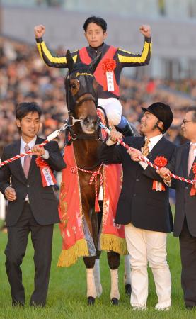 　史上初の３歳牝馬によるジャパンＣ制覇を成し遂げたジェンティルドンナの馬上でガッツポーズを決める岩田