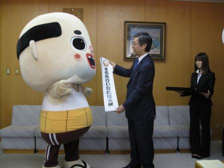 　そのだけいば応援大委嘱状交付式で金澤和夫兵庫県副知事（右）から激励された、ちっちゃいおっさん＝兵庫県庁