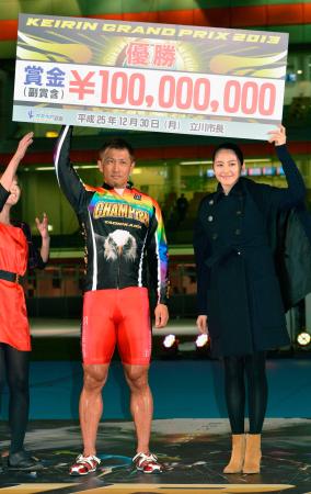 　優勝し賞金ボードを掲げる金子貴志。右は女優の長澤まさみ