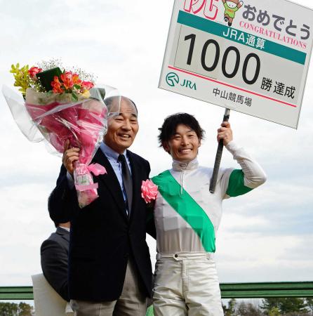 　１０００勝を達成し後藤（右）と笑顔で花束を掲げる松山康師（撮影・三好信也）