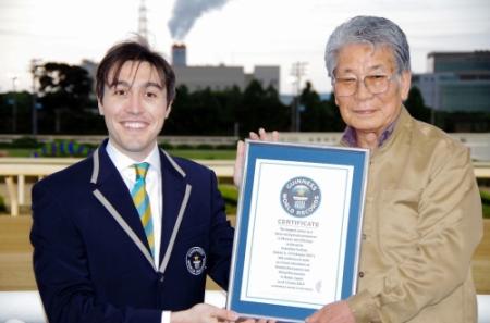 公式認定員からギネス世界記録公式認定証を受け取った吉田勝彦アナウンサー（右）
