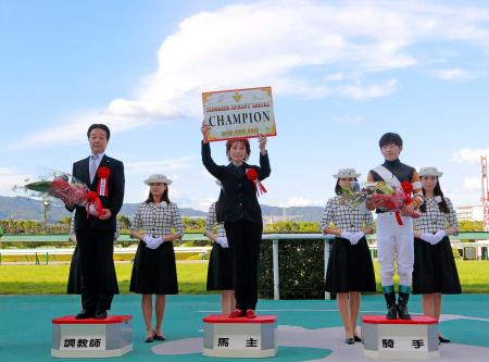 　リトルゲルダがサマースプリントチャンピオンに輝き、賞金ボードを掲げる栗山オーナー。左は鮫島師、右は丸田