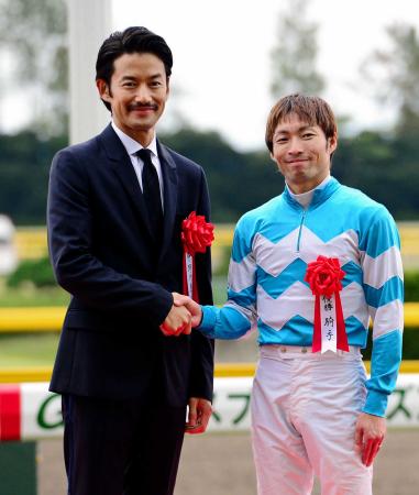 　表彰式で笑顔で握手する大野（右）とプレゼンターの竹野内豊