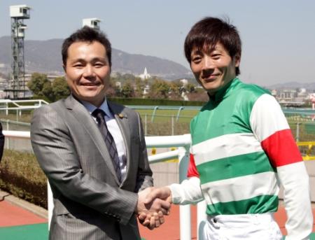 　阪神３Ｒ、西村真幸調教師（左）は厩舎開業でＪＲＡ初勝利を挙げ佐藤友則騎手と握手を交わす