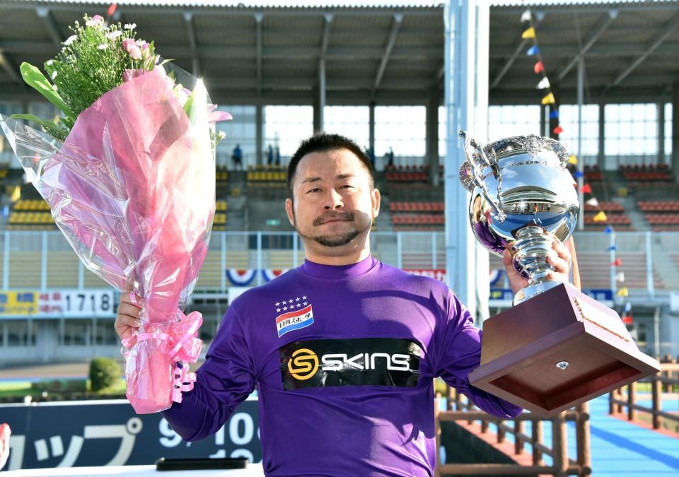 　優勝し、カップを掲げる山崎芳仁