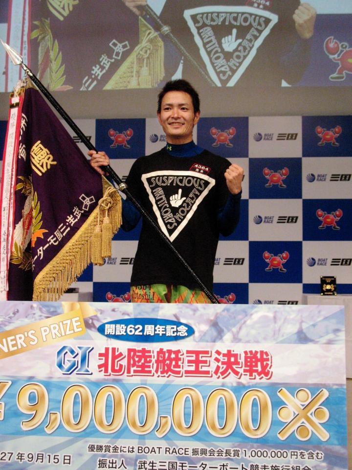 優勝旗を手に笑顔を見せる池永太